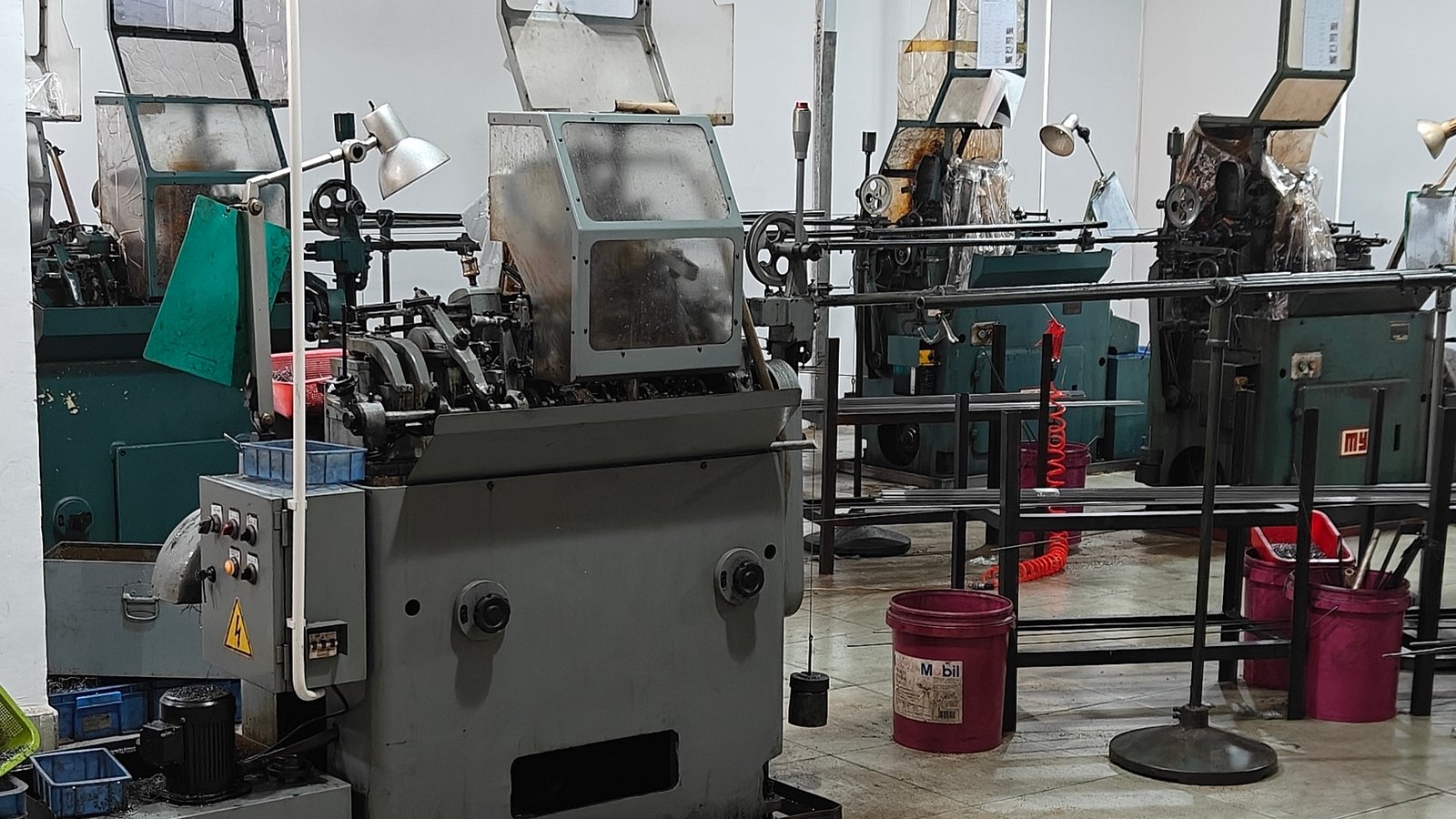 A row of automatic machines forming small metal parts