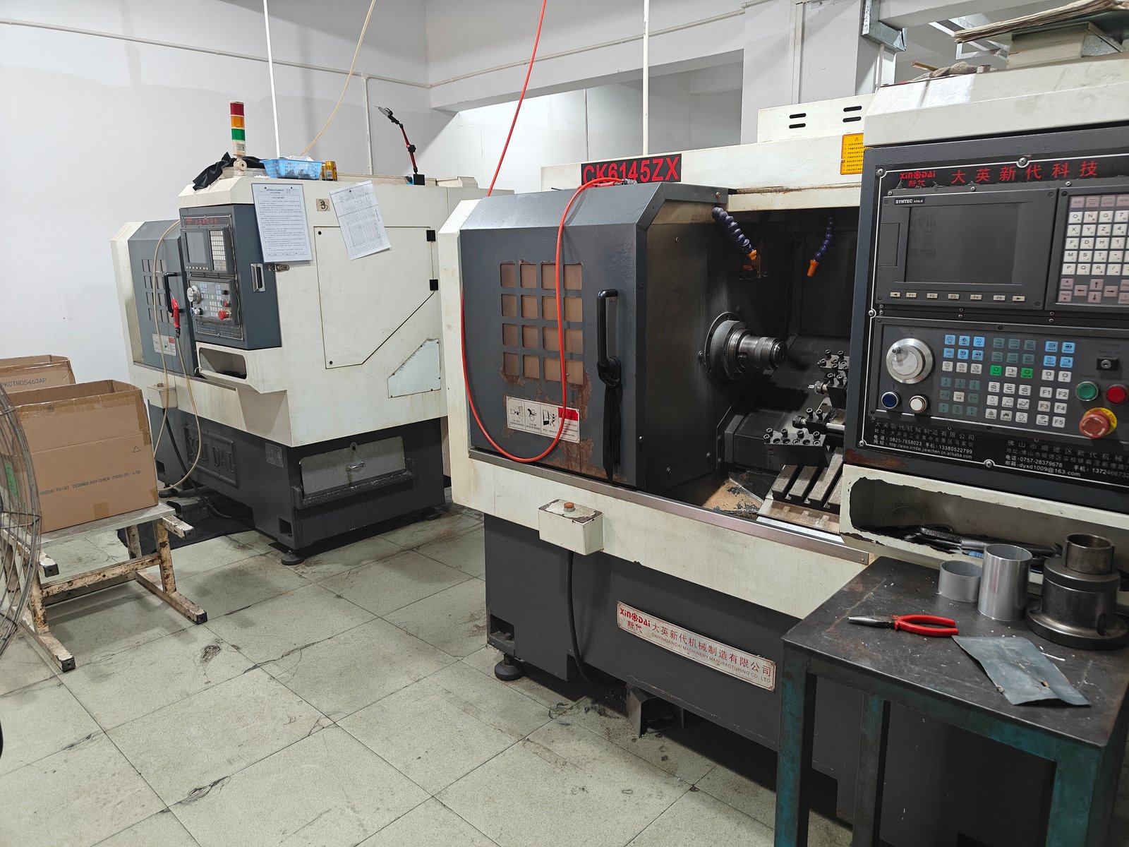 Two CNC lathes on the Yuehang machine floor, one with the chuck open
